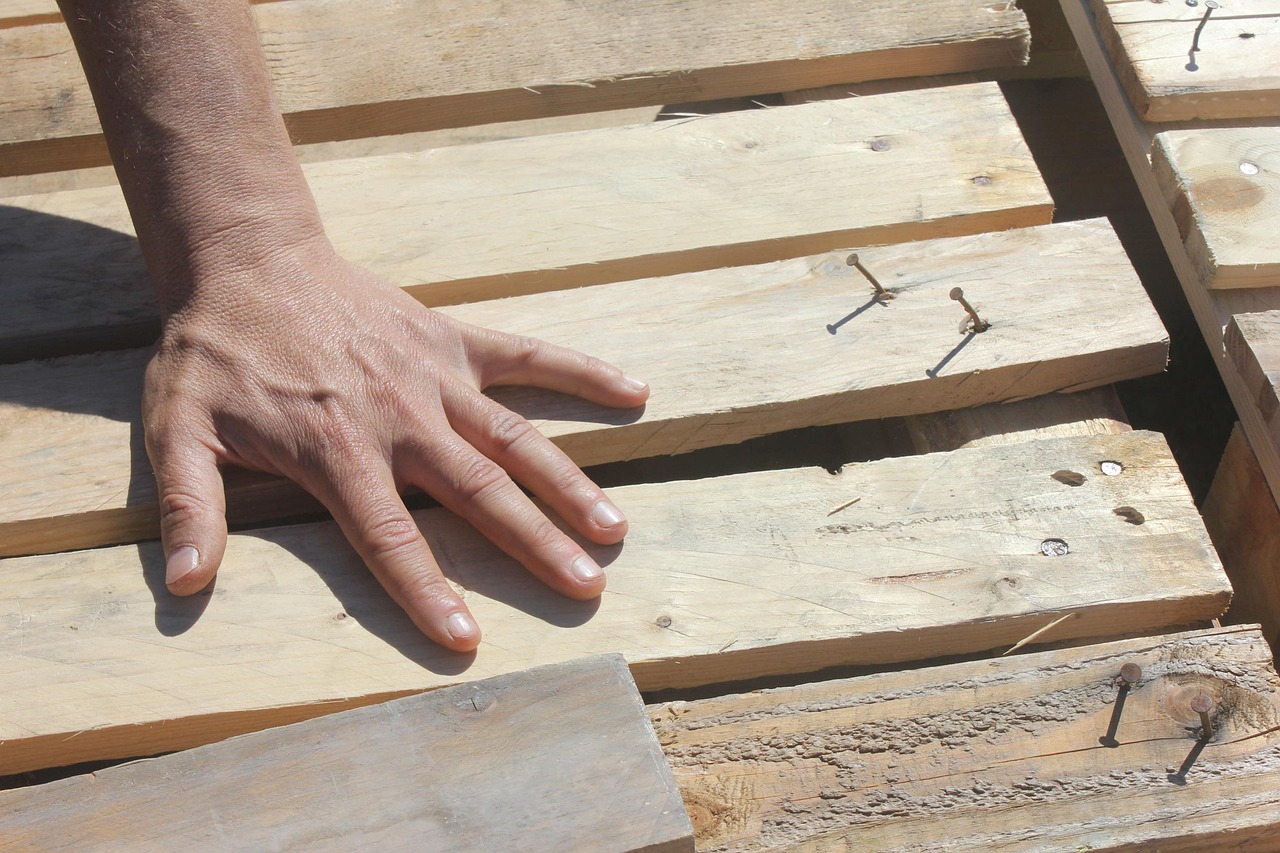 Artisan charpentier dans son atelier façonnant des pièces de bois de bout et assemblages traditionnels